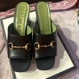 Gucci Black Mules with Gold Detail
Authentic